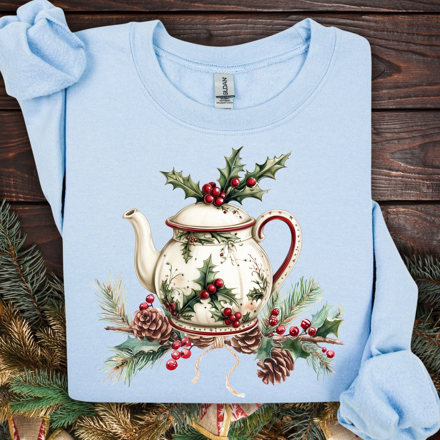 Light blue Gildan sweatshirt with a vintage Christmas teapot, holly, and pinecone design.