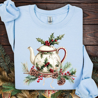 Light blue Gildan sweatshirt with a vintage Christmas teapot, holly, and pinecone design.
