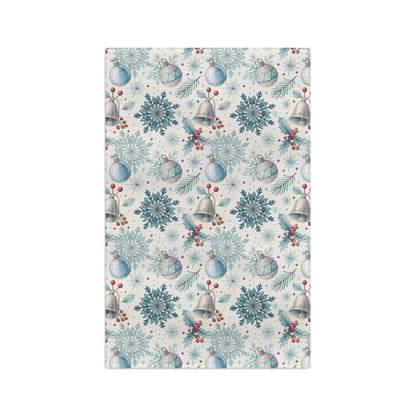 Microfiber tea towel with a muted blue and silver winter holiday pattern of bells, snowflakes, and berries.