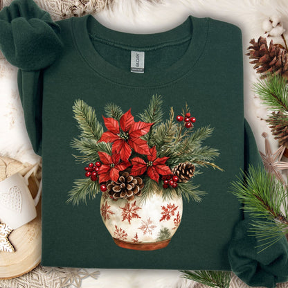 Forest Green Gildan long sleeve tee with watercolor poinsettia, pinecone, and evergreen floral arrangement in a snowflake pot.