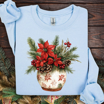 Light blue Gildan long sleeve tee with watercolor poinsettia, pinecone, and holly floral arrangement in a snowflake pot.