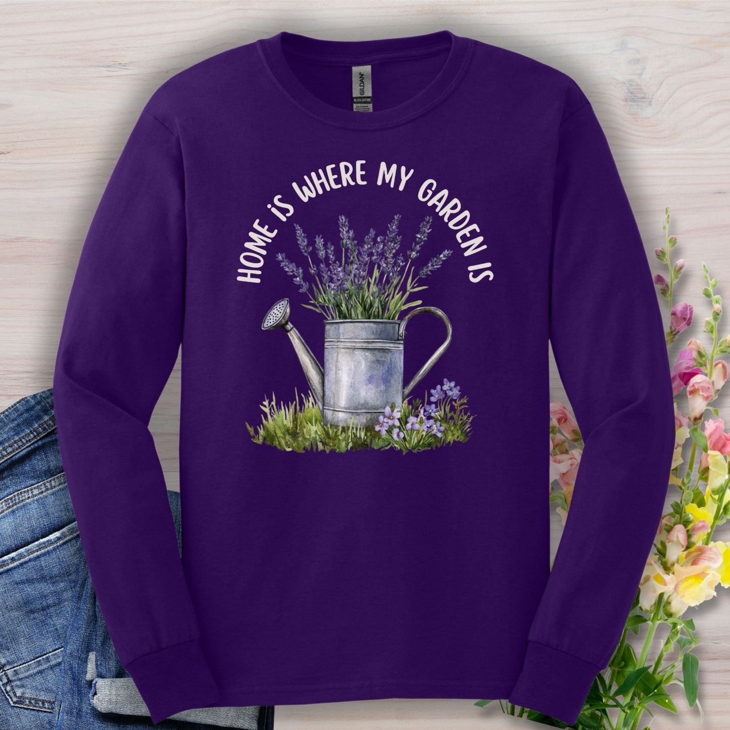 Purple long sleeve tee with "Home Is Where My Garden Is" text, a watercolor watering can, and lavender sprigs.