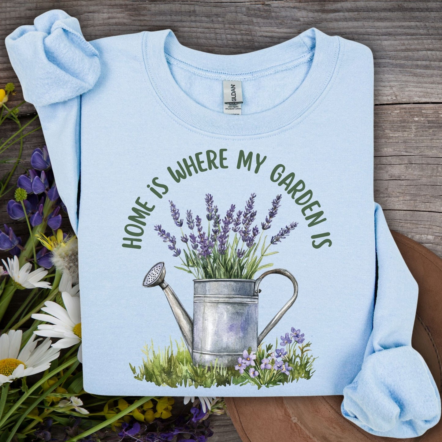 Light blue crewneck sweatshirt with "Home is where my garden is" text and a watercolor watering can with lavender.