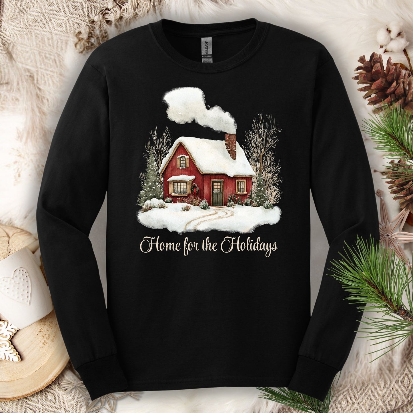 Black Gildan long sleeve tee with a watercolor red winter cabin and "Home for the Holidays" script.