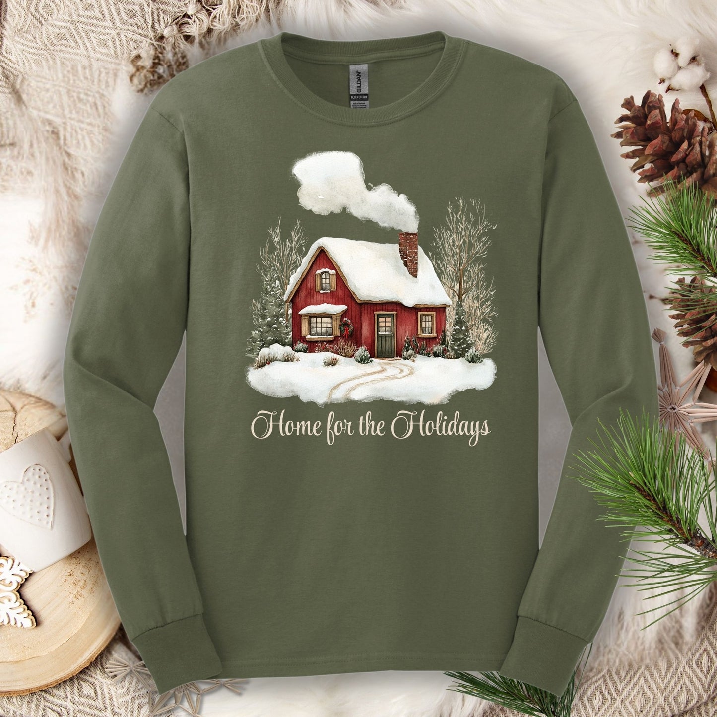 Military Green Gildan Softstyle long sleeve tee with watercolor red cabin, evergreens, and "Home for the Holidays" script.