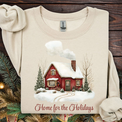 Sand Gildan fleece sweatshirt with vintage watercolor red cabin and "Home for the Holidays" text.