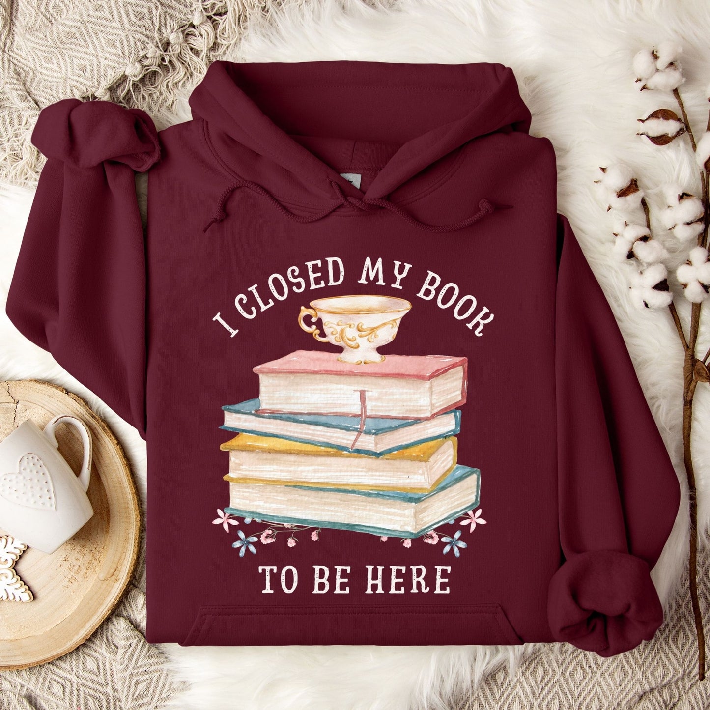 Maroon Gildan 18500 hoodie with "I Closed My Book To Be Here" text, stacked books, and teacup design.
