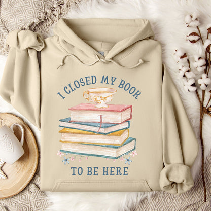 Sand Gildan 18500 hoodie with "I Closed My Book To Be Here" text, stacked books, and teacup graphic.