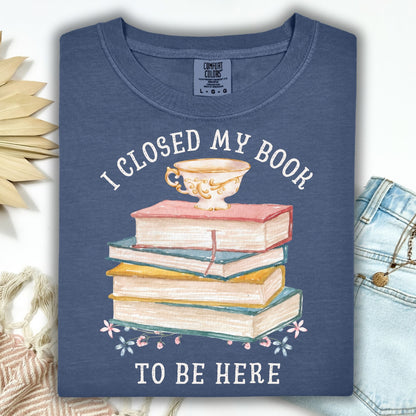 Denim blue "I Closed My Book To Be Here" tee with watercolor books, teacup, and florals.
