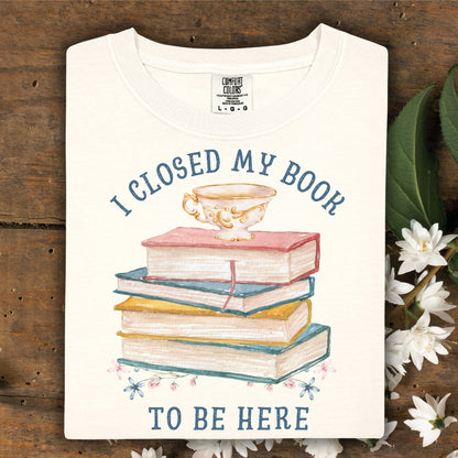 Ivory "I Closed My Book To Be Here" t-shirt with watercolor books, teacup, and florals.