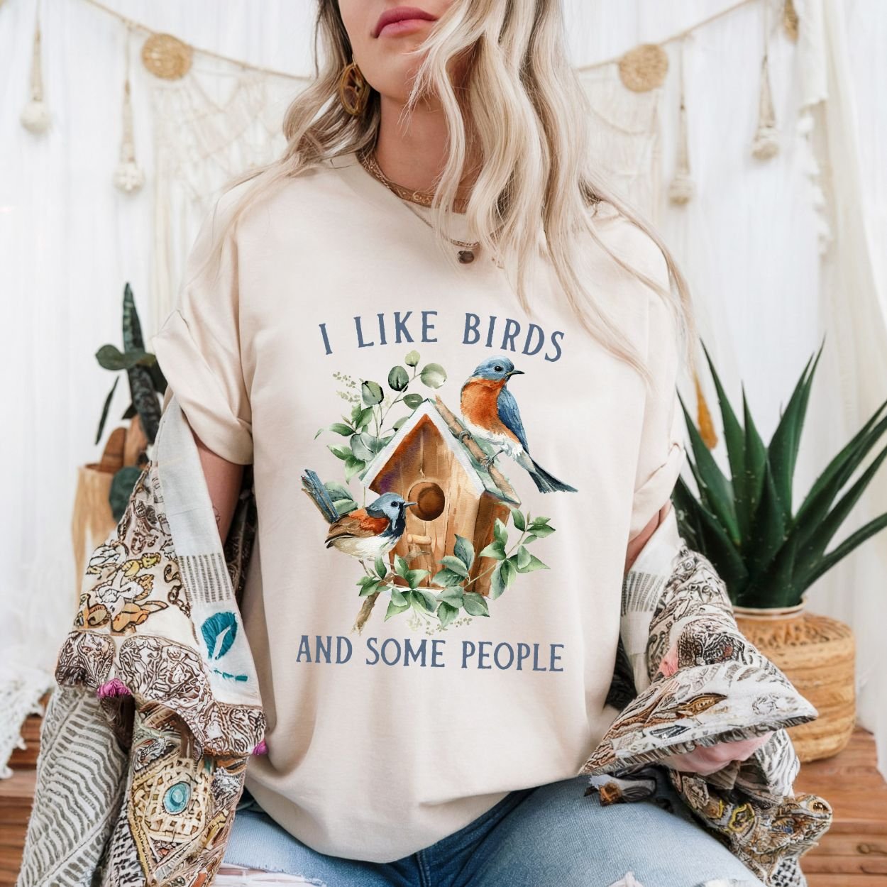 Natural cotton t-shirt with "I like birds and some people" text and watercolor bluebirds on a birdhouse.
