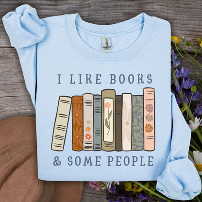 Light blue Gildan crewneck sweatshirt with "I like books & some people" and a row of vintage books graphic.