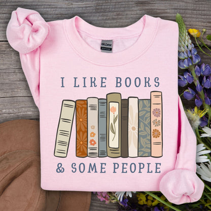 Light pink Gildan sweatshirt with "I like books & some people" and a row of vintage books graphic.