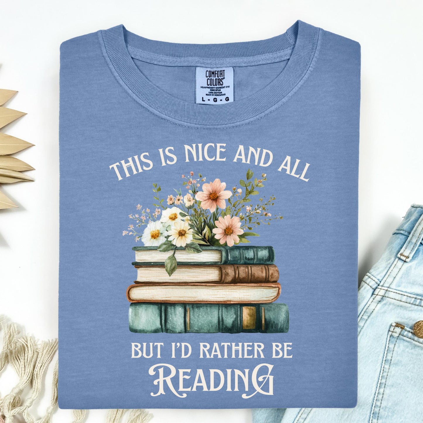 Blue Jean Comfort Colors t-shirt with "This is nice and all but I'd rather be reading" text and vintage books with wildflowers.
