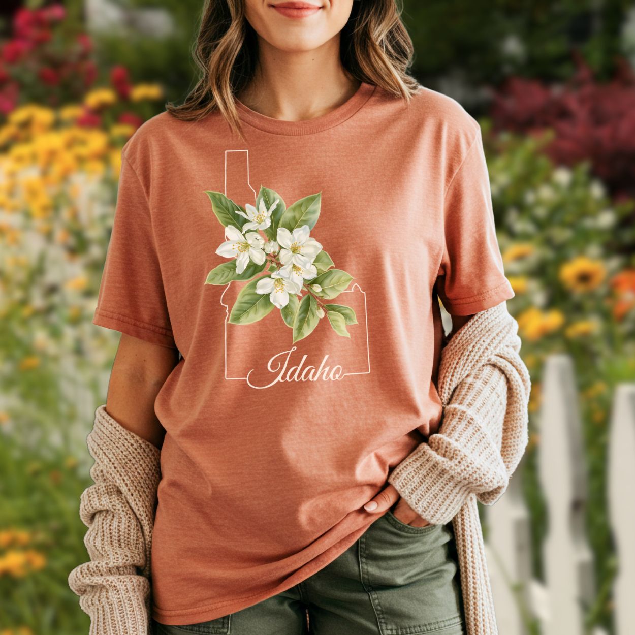 Garment-dyed terracotta t-shirt with Idaho outline, Syringa blossoms, and "Idaho" script.
