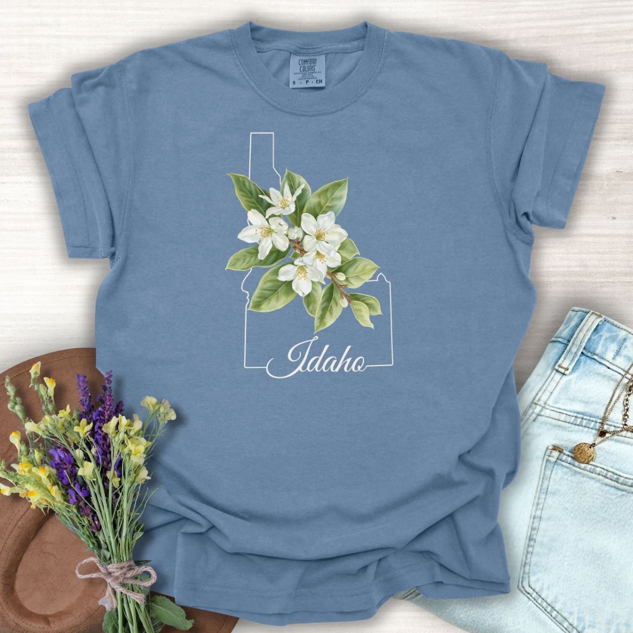 Blue Jean S t-shirt with Idaho outline, Syringa flowers, and "Idaho" script.
