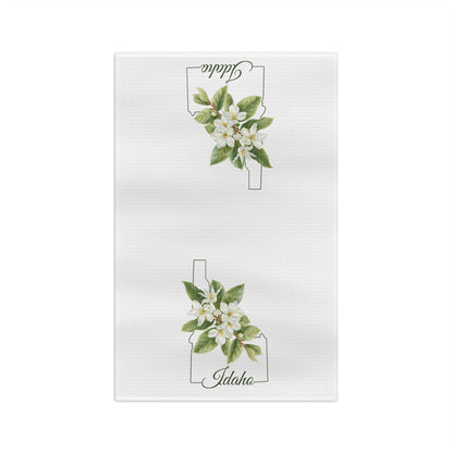 White microfiber tea towel with Idaho state outline and Syringa (mock orange) blossoms.