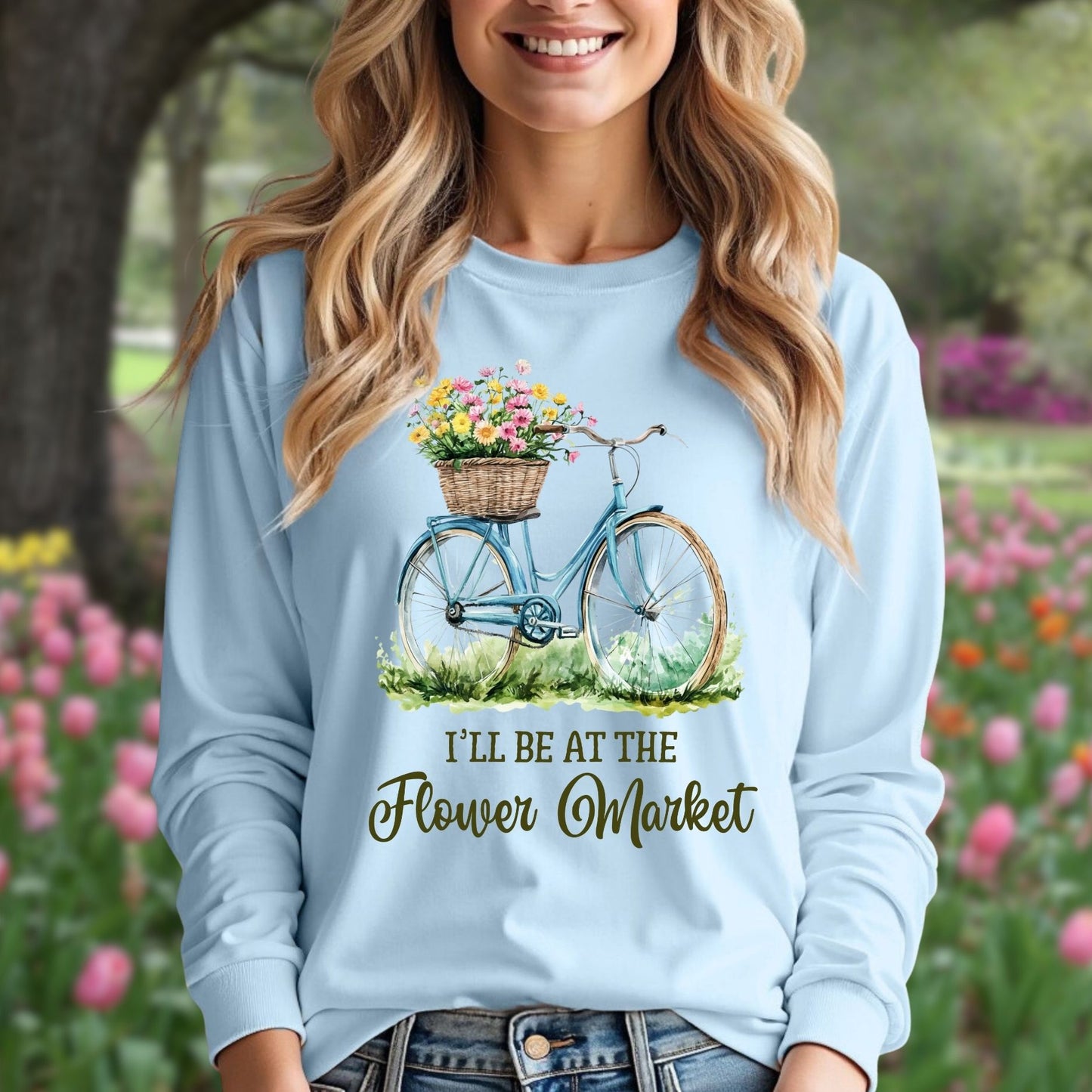 Light blue long sleeve tee with a vintage bicycle and flower basket graphic, "I'll Be At The Flower Market" text.