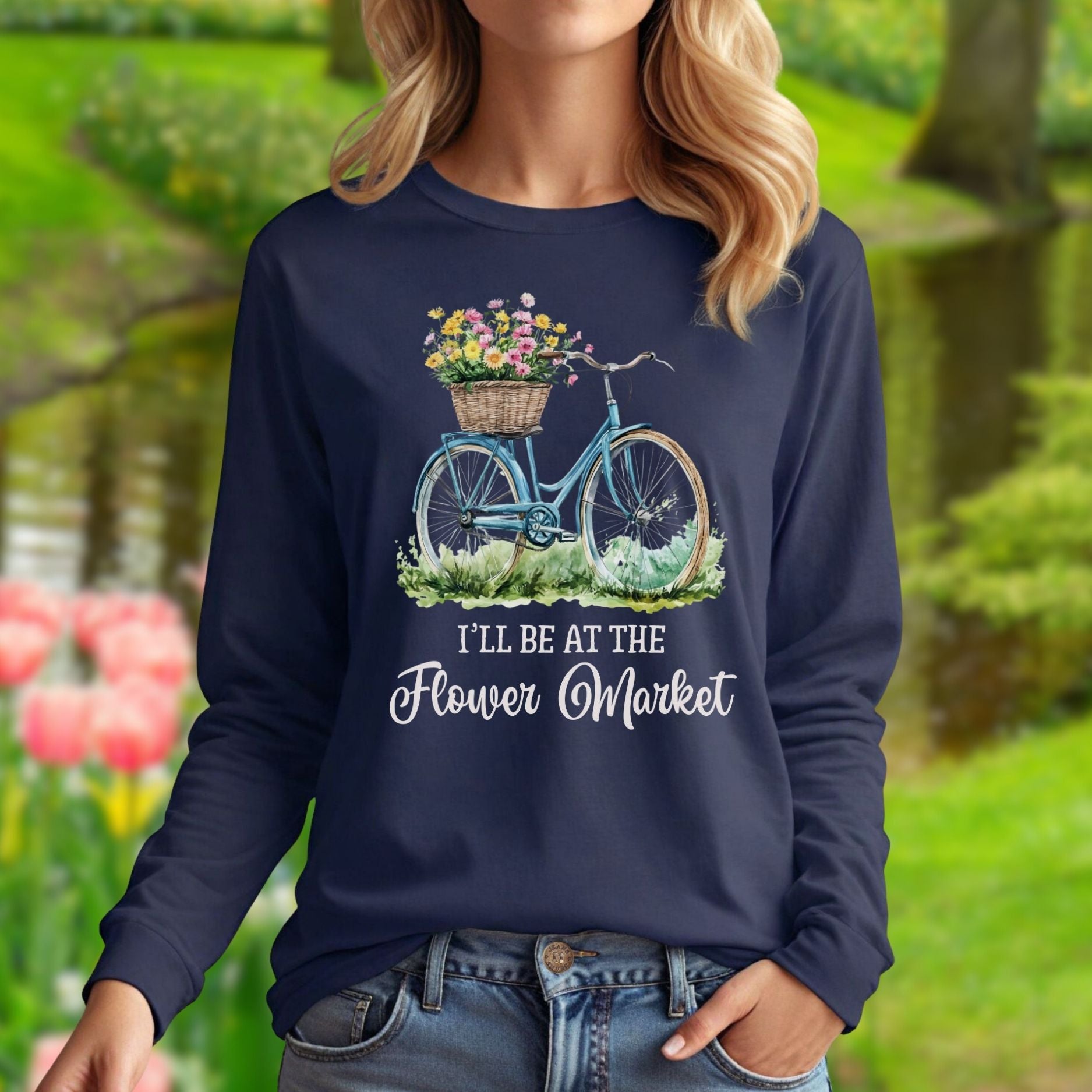 Navy long sleeve tee with a vintage bicycle and pastel flower basket graphic, "I'll Be At The Flower Market" text.