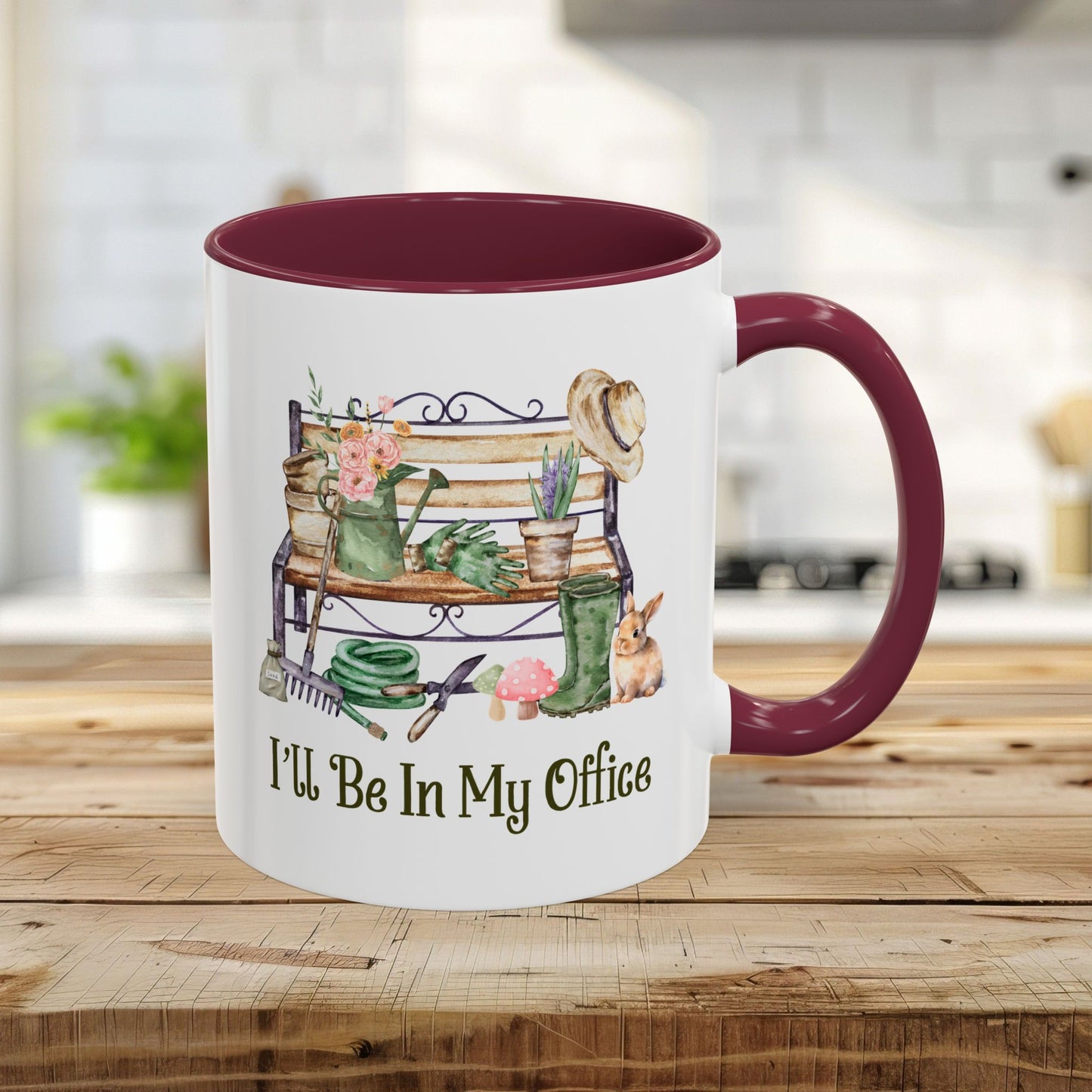 11oz ceramic gardener mug with maroon interior/handle, featuring "I'll Be In My Office" and garden tools illustration.