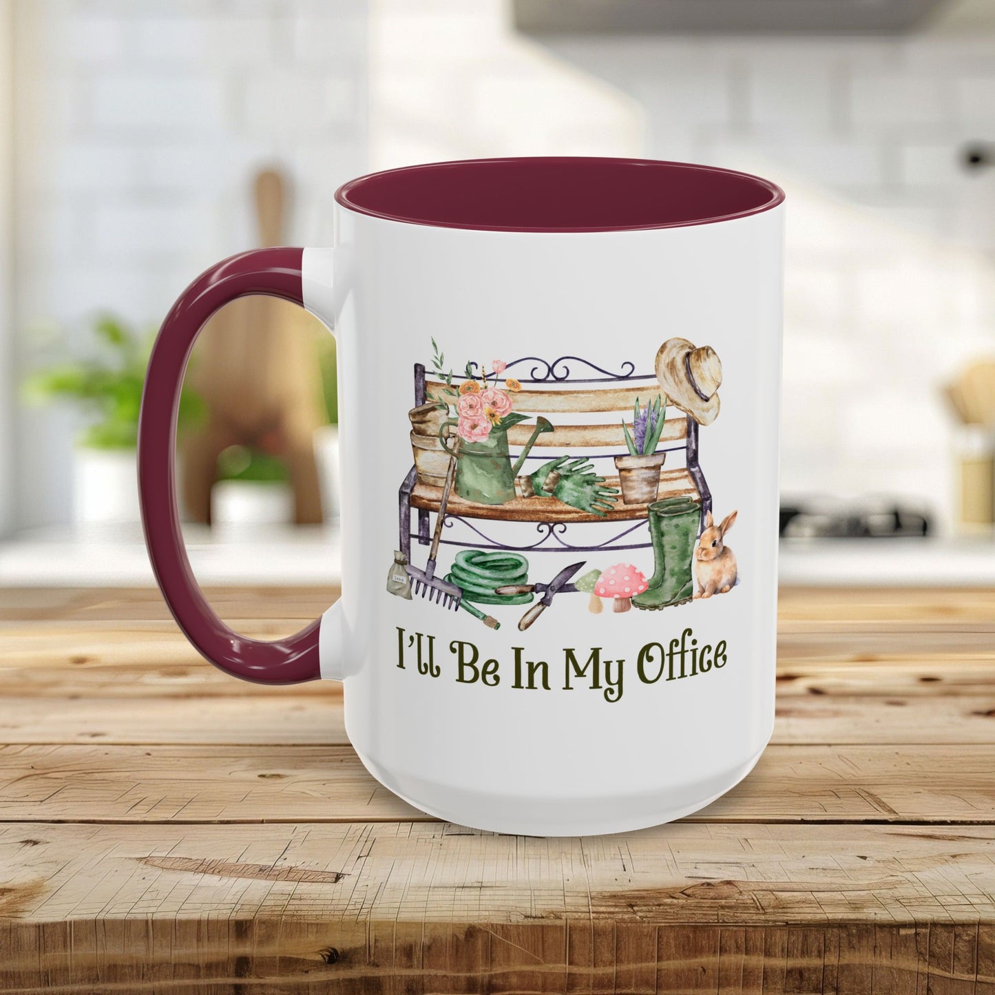 White ceramic gardener mug with a maroon handle and interior, featuring watercolor garden tools and "I'll Be In My Office.