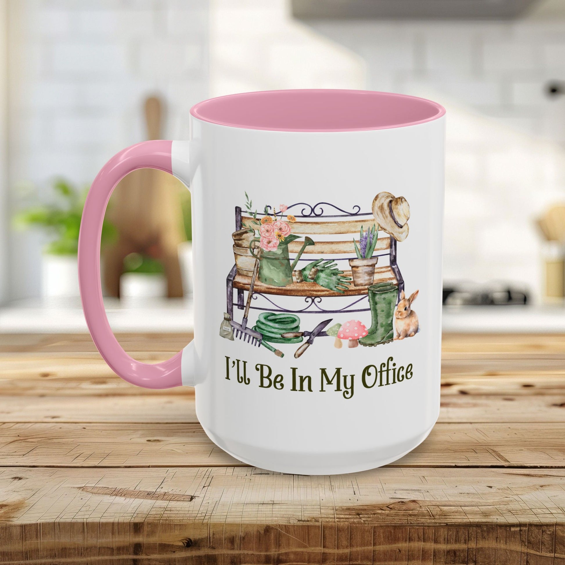 White ceramic 15oz mug with pink interior and handle, featuring "I'll Be In My Office" and garden illustrations.