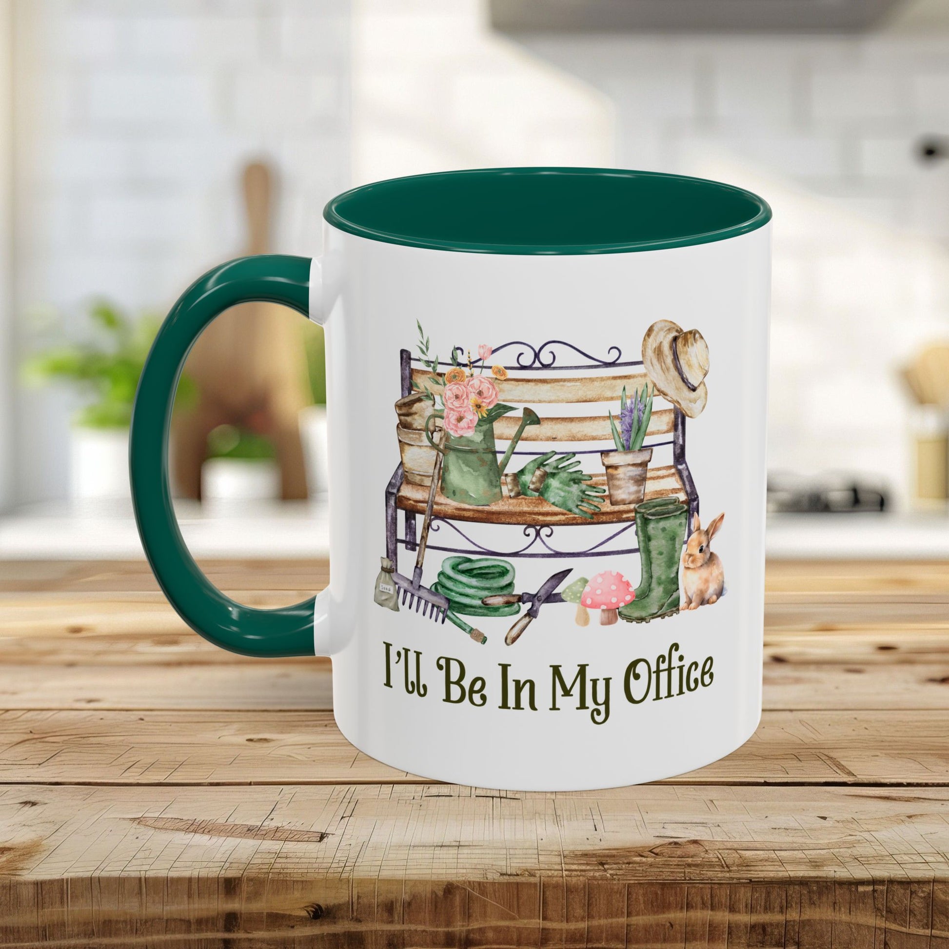 White ceramic mug with green handle and interior, featuring watercolor garden tools and "I'll Be In My Office.