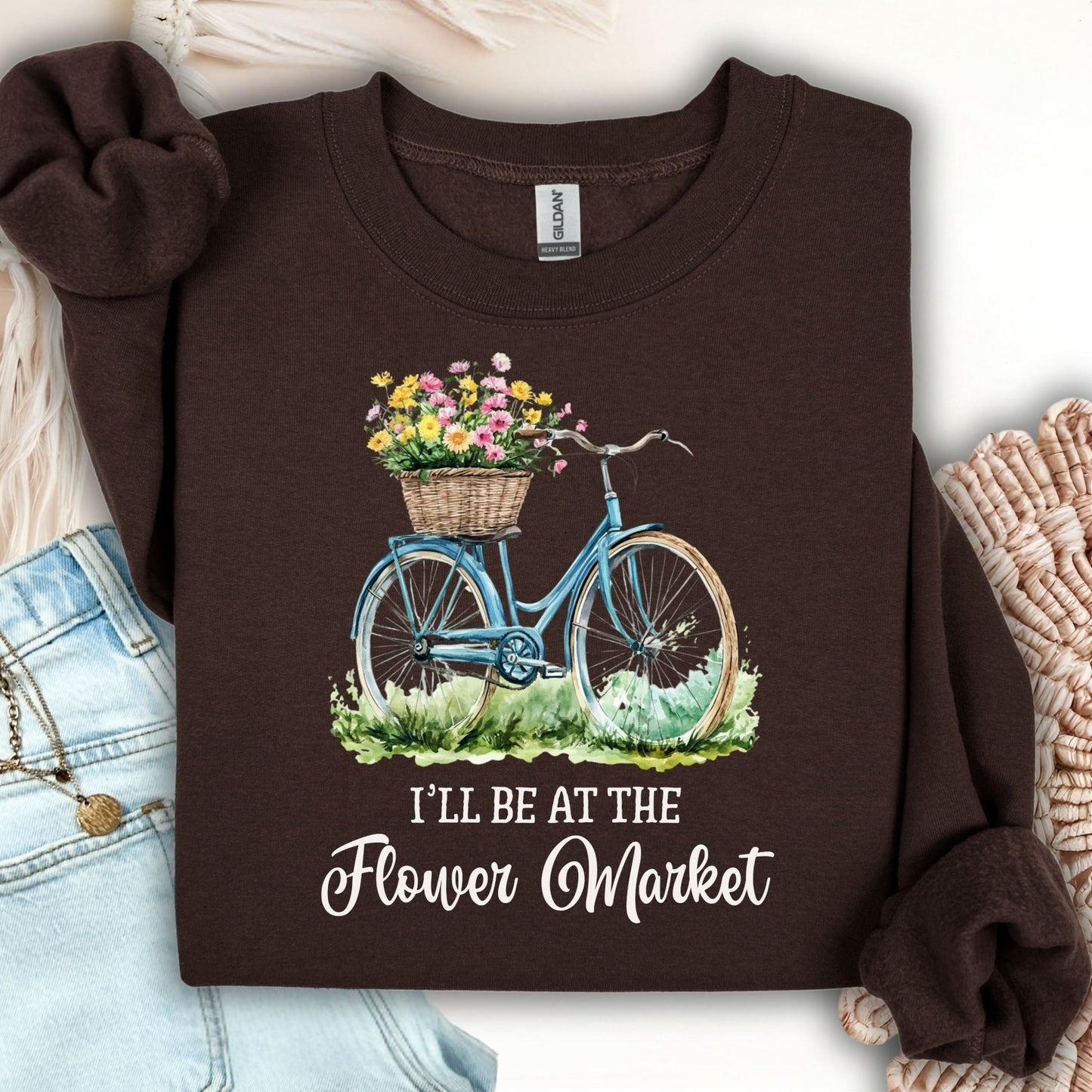 Dark chocolate crewneck sweatshirt with a blue bicycle, flower basket, and "I'll Be at the Flower Market" text.