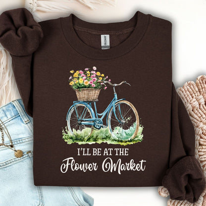 Dark chocolate crewneck sweatshirt with a blue bicycle, flower basket, and "I'll Be at the Flower Market" text.
