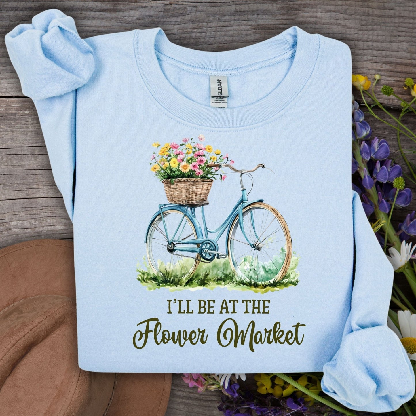 Light blue crewneck sweatshirt with a bicycle and flower basket graphic, "I'll be at the Flower Market" text.