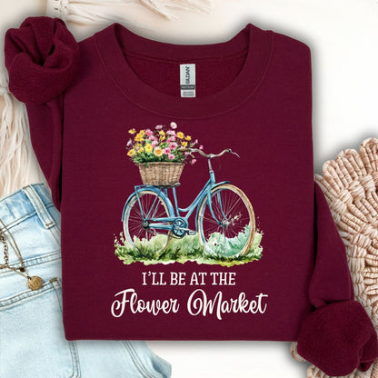 Maroon crewneck sweatshirt with a blue bicycle, flower basket, and "I'll Be at the Flower Market" text.