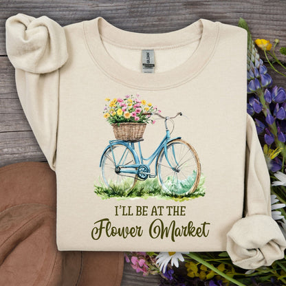 Sand "I'll Be at the Flower Market" sweatshirt with a blue bicycle and flower basket design.