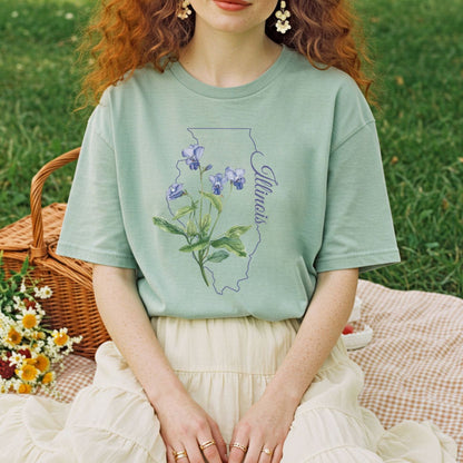 Sage green t-shirt with a blue violet illustration over an Illinois state outline.