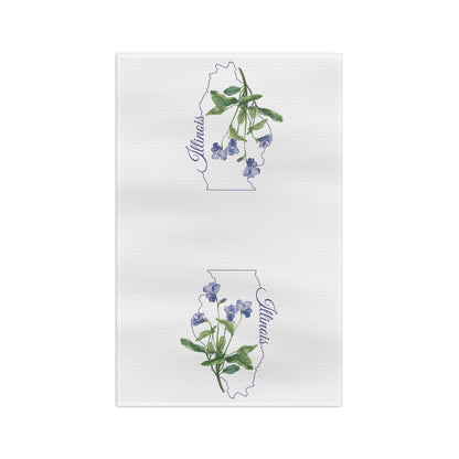 White microfiber tea towel with watercolor blue violets over a subtle Illinois state outline and script "Illinois.