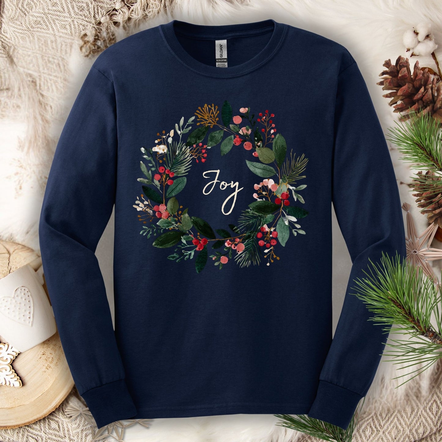 Navy Gildan long sleeve tee with a watercolor Christmas wreath and "Joy" in the center.