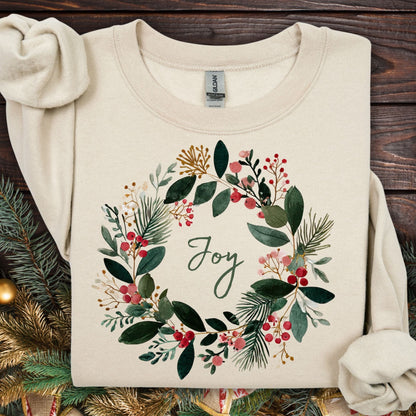 Sand Gildan crewneck sweatshirt with a watercolor Christmas wreath and "Joy" in the center.