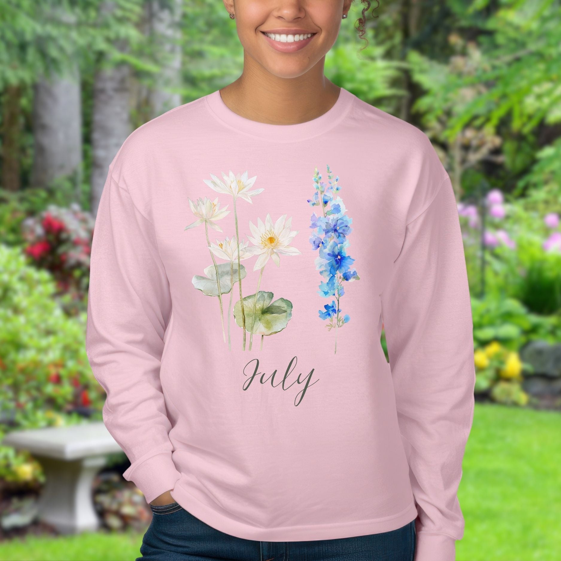 Pink long-sleeve tee with watercolor waterlily and larkspur flowers, "July" script.