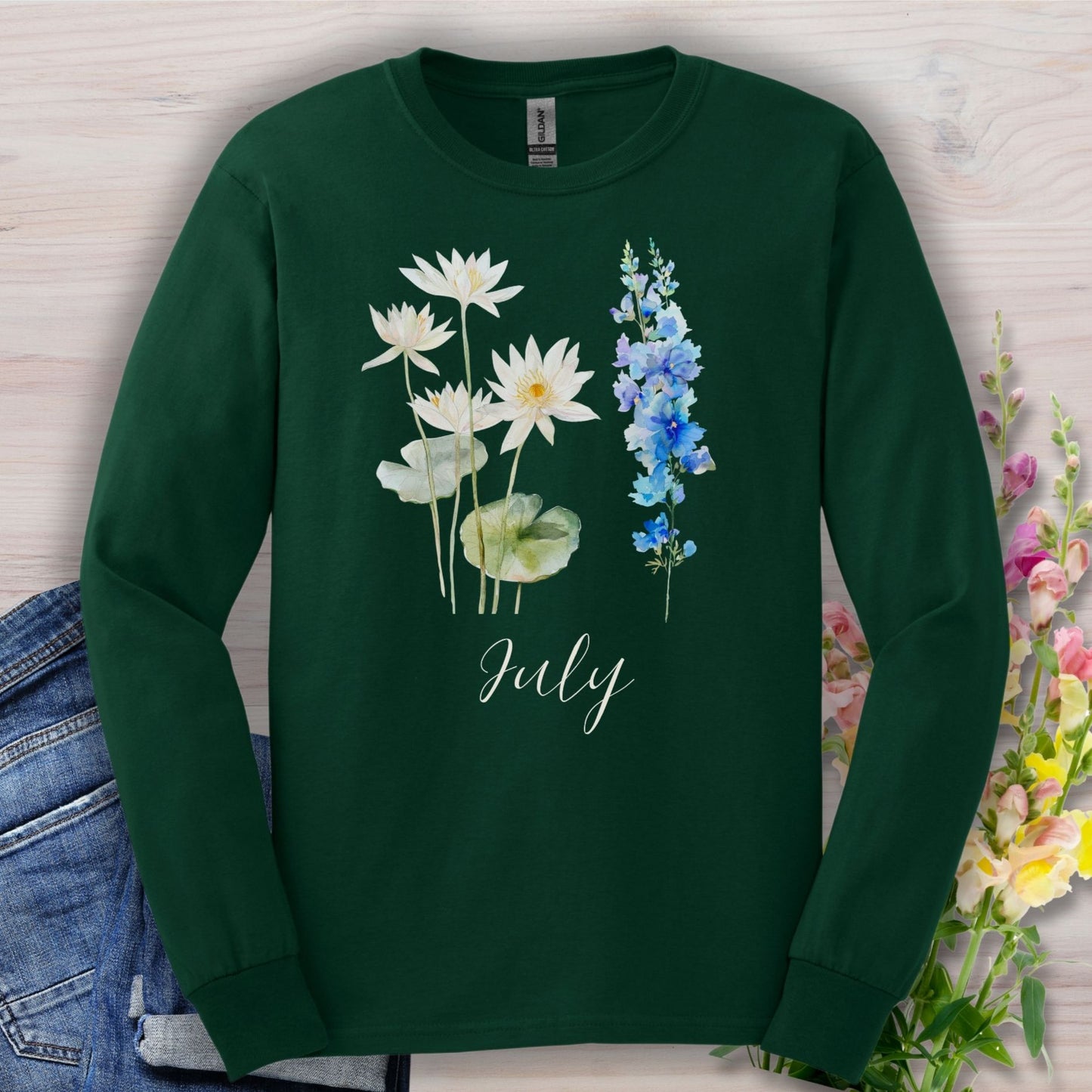 Forest green long sleeve tee with watercolor waterlilies, larkspur, and "July" script.