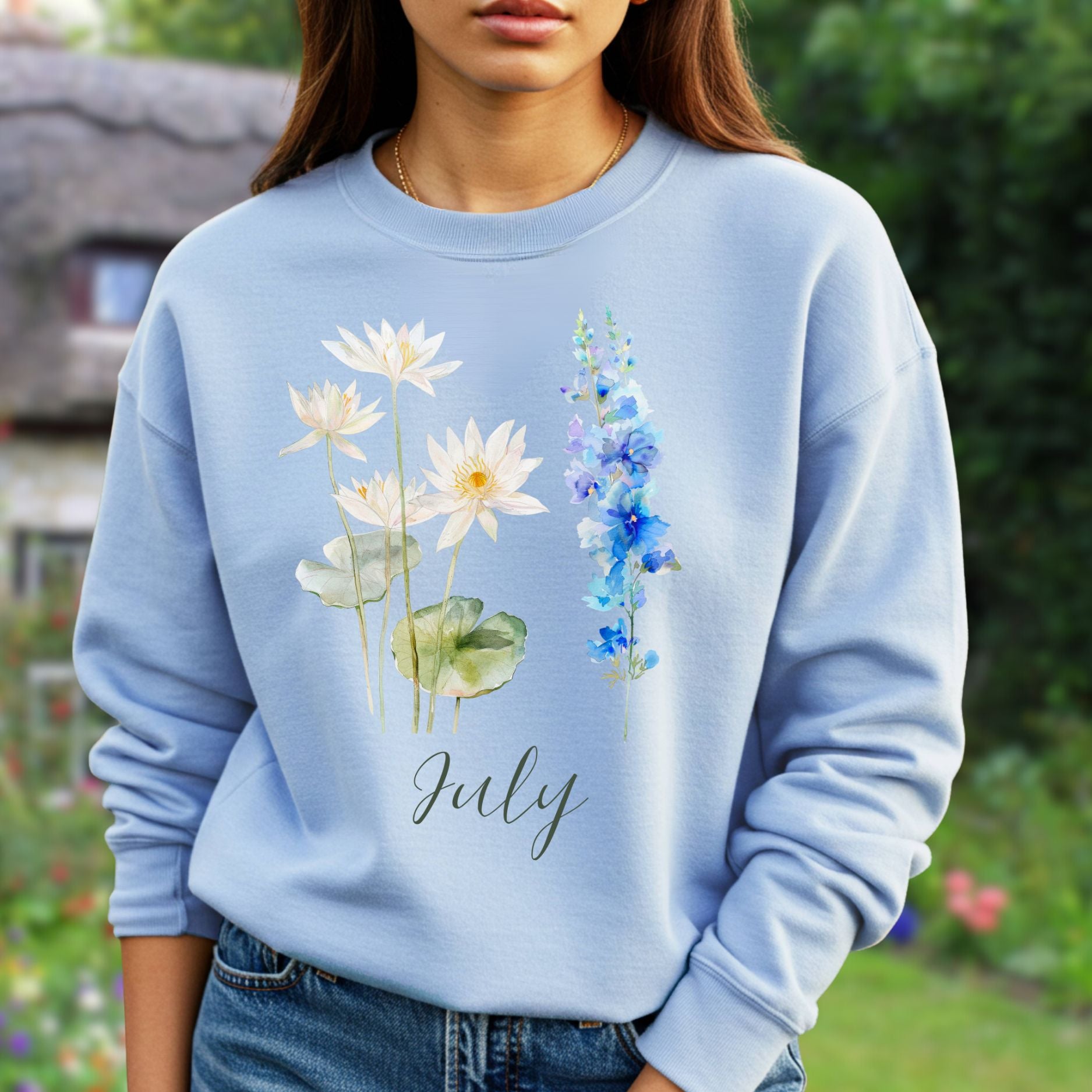 Light blue crewneck sweatshirt with watercolor waterlilies, larkspur, and "July" text.