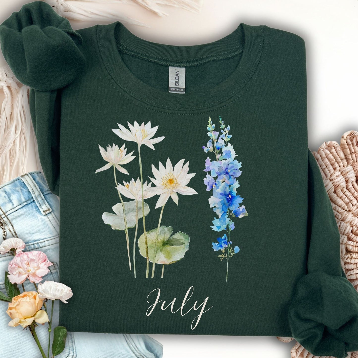 Forest Green unisex sweatshirt with watercolor waterlilies, larkspur, and "July" text.