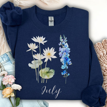 Navy unisex sweatshirt with watercolor waterlilies, larkspur, and "July" text.