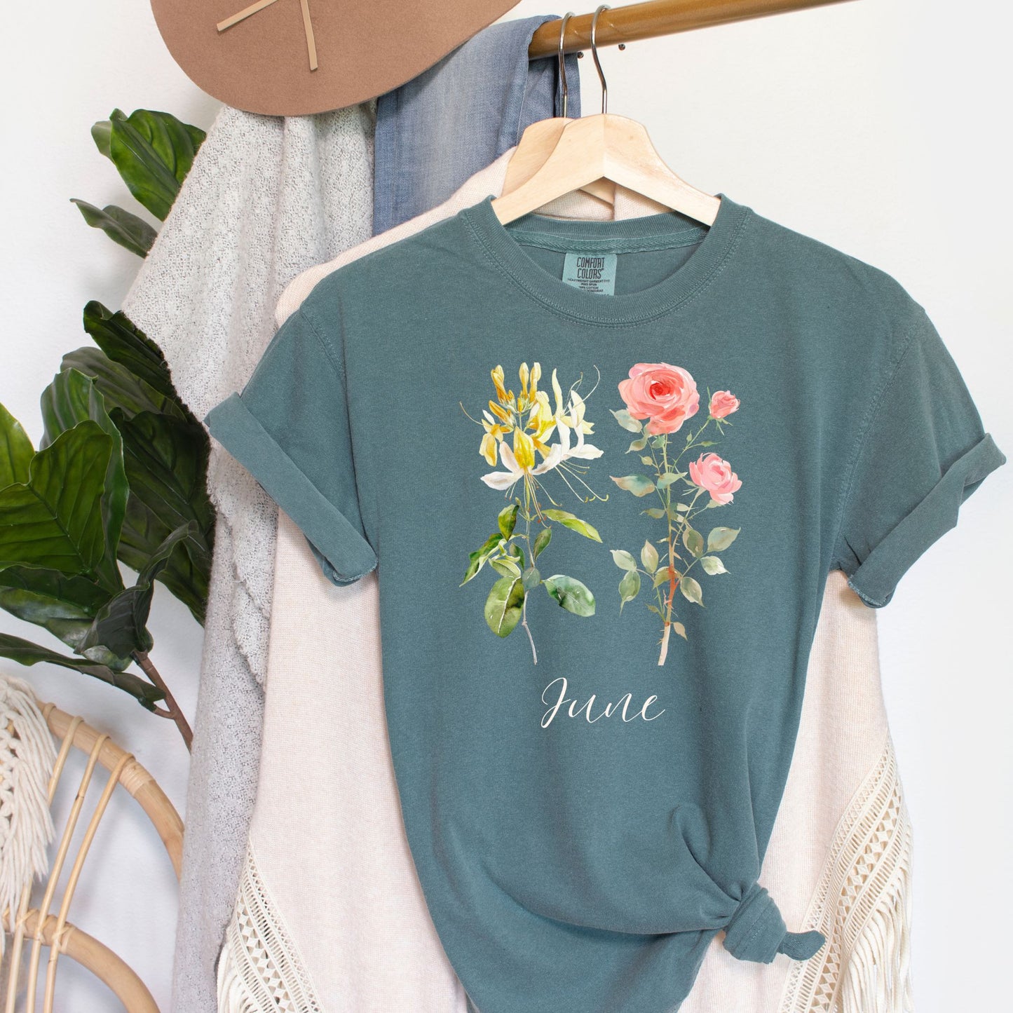 Garment-dyed teal cotton t-shirt with watercolor honeysuckle, rose, and "June" design.