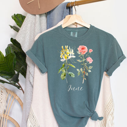 Garment-dyed teal cotton t-shirt with watercolor honeysuckle, rose, and "June" design.