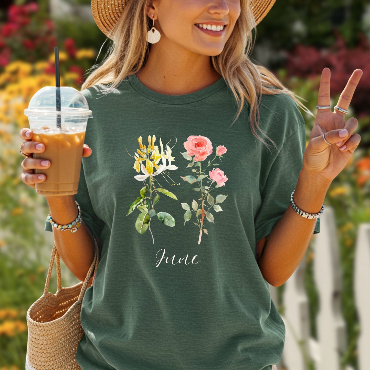 Woman in a relaxed-fit, dark green June birth month flower t-shirt with honeysuckle and rose watercolor art.