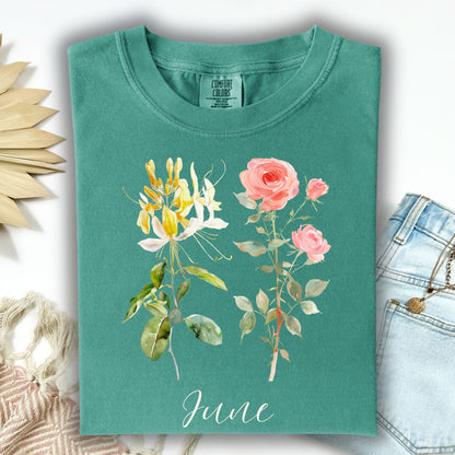 Garment-dyed teal cotton t-shirt with watercolor honeysuckle, rose, and "June" graphic.