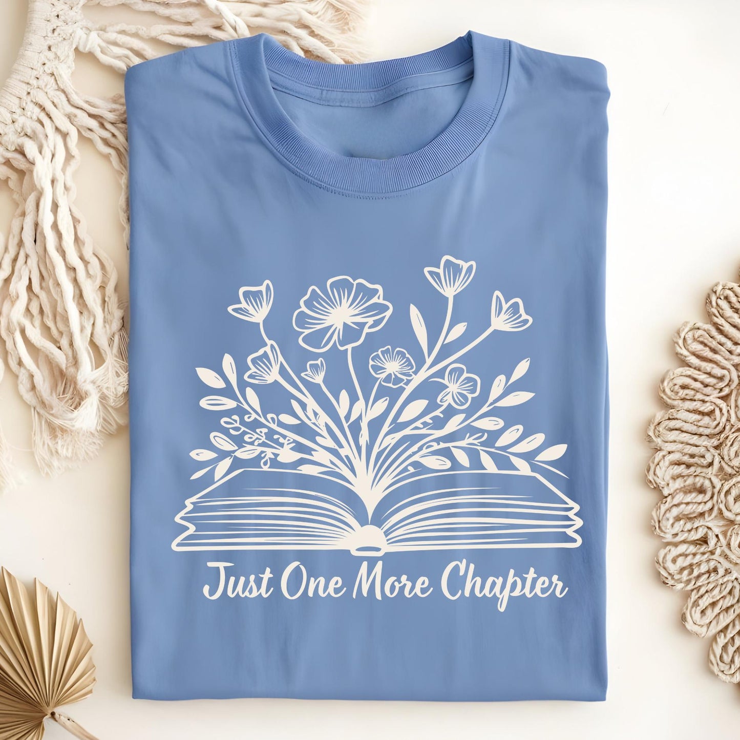 Carolina Blue "Just One More Chapter" t-shirt with white floral book graphic, size S.