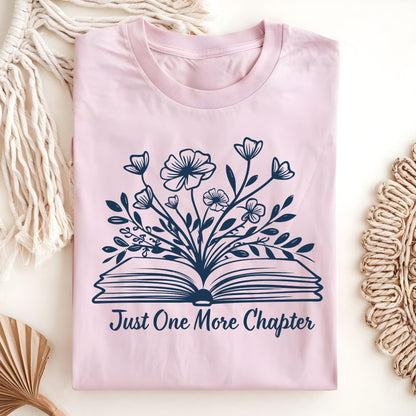 Light pink "Just One More Chapter" t-shirt with a dark blue floral book design.