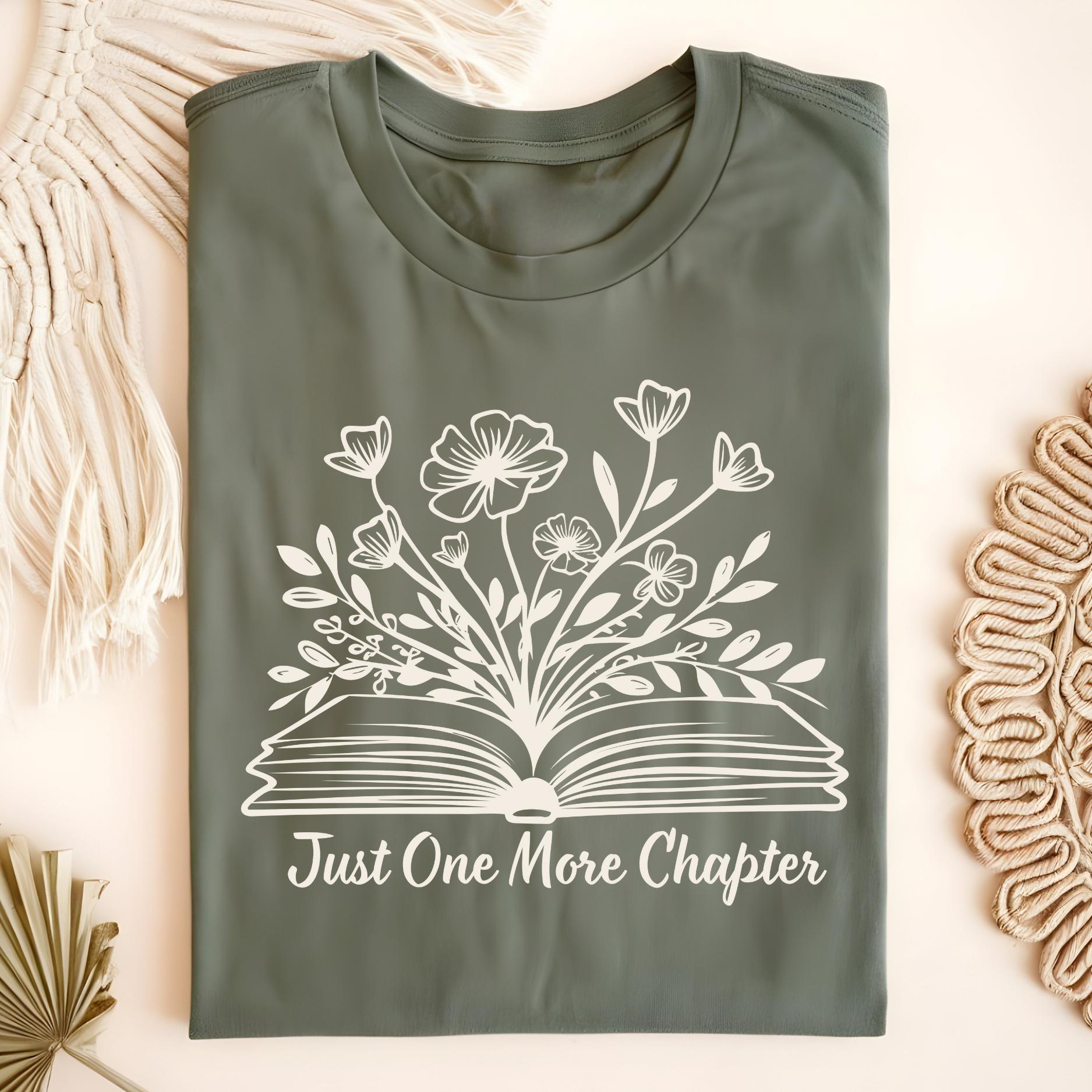 Military Green "Just One More Chapter" t-shirt with white wildflowers blooming from an open book.