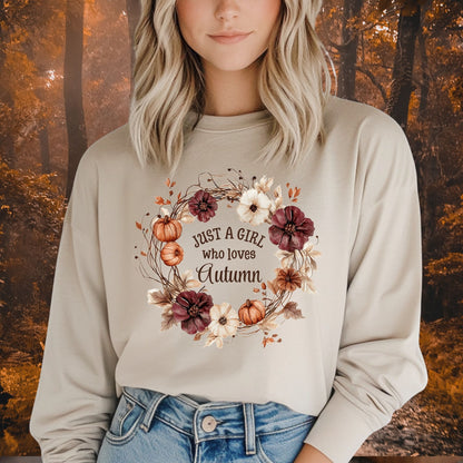 Beige long sleeve tee with "Just a Girl who loves Autumn" text in a watercolor wreath of pumpkins and flowers.