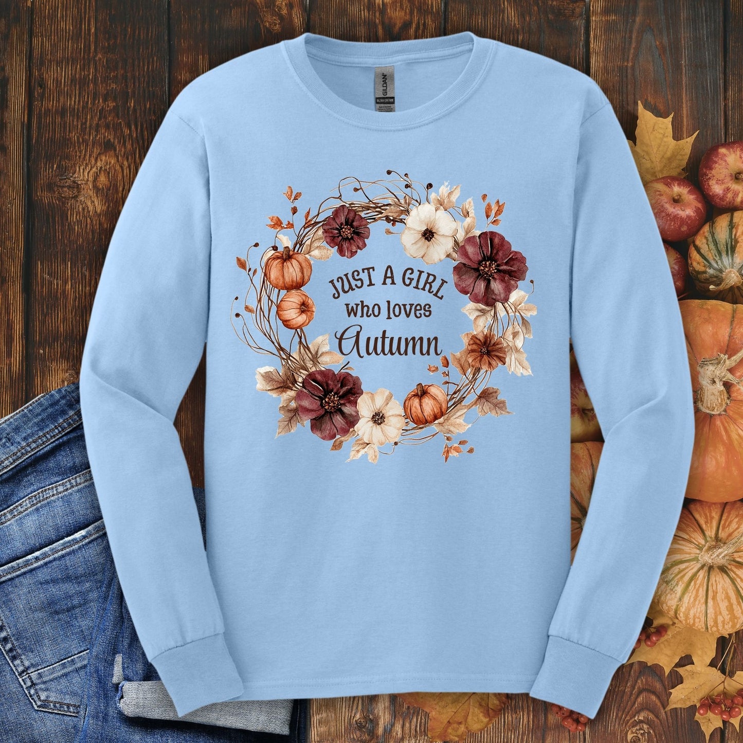 Light blue Gildan long sleeve tee with "Just a Girl who loves Autumn" in a watercolor pumpkin and floral wreath.
